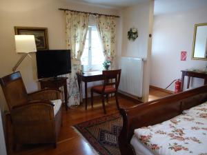 een slaapkamer met een bed, een bureau en een televisie bij Am Alten Fronhof in Bergisch Gladbach