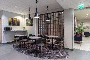 a restaurant with tables and chairs in a lobby at Scandic Joensuu in Joensuu