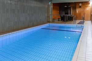 ein großer Pool mit blauen Bodenfliesen in der Unterkunft Scandic Hämeenlinna City in Hämeenlinna