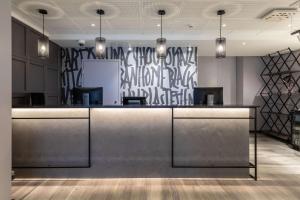 a lobby with a reception counter with graffiti on the wall at Scandic Kallio in Helsinki
