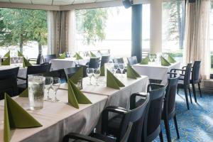 a row of tables in a room with green napkins at Scandic Waskia in Vaasa