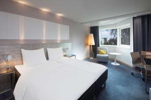 a hotel room with a large bed and a large window at Scandic Royal Stavanger in Stavanger