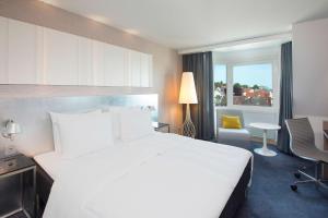 a hotel room with a large bed and a large window at Scandic Royal Stavanger in Stavanger
