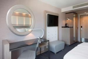Scandic Royal Stavanger في ستافانغر: غرفة نوم مع مرآة ومكتب وسرير