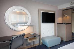 a bedroom with a desk and a mirror and a chair at Scandic Royal Stavanger in Stavanger