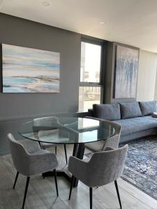 a living room with a glass table and chairs at Umhlanga Arch Gem in Durban