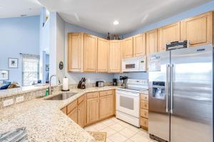 a kitchen with wooden cabinets and a stainless steel refrigerator at Bear Trap Dunes - 58D October Glory in Ocean View