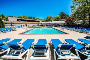 a group of blue lounge chairs and a swimming pool at Sea Mist Resort, a VRI resort in Mashpee