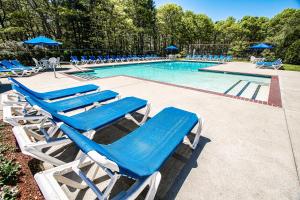 a group of blue lounge chairs and a swimming pool at Sea Mist Resort in Mashpee