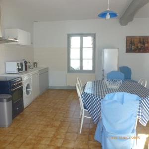 a kitchen and dining room with a table and a kitchen with a stove at Gîte A l'ombre de l'Abbaye in Faverolles-sur-Cher