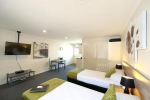 Habitación de hotel con 2 camas y mesa en Havelock North Motor Lodge en Havelock North