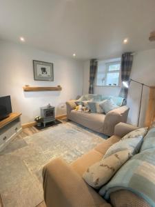 a living room with a couch and a tv at Sheilas Cottage Sleeps 2 One dog allowed with prior permission in Barnard Castle