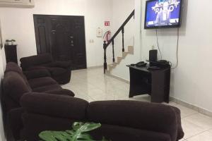 sala de estar con sofá y TV de pantalla plana en Aloja en Monterrey