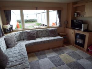 a living room with a couch in front of a window at Boquhanran Caravan, Whitley Bay in Hartley