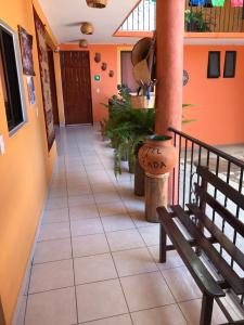 a hallway with a bench in a building with orange walls at Hotel La Cascada in Oaxaca City