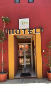 a hotel entrance with a sign on a red wall at Hotel La Cascada in Oaxaca City