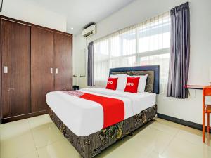 a bedroom with a large bed with red pillows at SUPER OYO 90324 Si Jalak Guest House in Lebakwangi