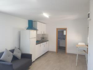 ein Wohnzimmer mit einem Sofa und einer Küche in der Unterkunft Alojamiento para descansar en tranquilidad con todo a mano in Santa Cruz de Tenerife