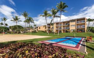 um resort com piscina e palmeiras em Kona Coast Resort em Kailua-Kona