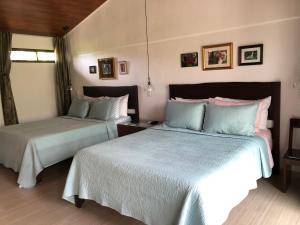 two beds in a hotel room with two beds at Casa Donna Rosa B&B in Nuevo Arenal