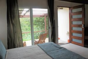 a bedroom with a bed and a sliding glass door at Casa Donna Rosa B&B in Nuevo Arenal