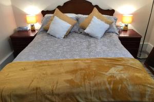 1 dormitorio con 1 cama con almohadas y 2 lámparas en Tranquil Welsh Mountain Gem, Abertillery, Wales, en Abertillery