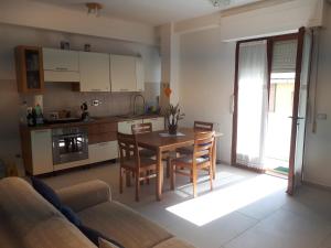 eine Küche und ein Esszimmer mit Tisch und Stühlen in der Unterkunft Appartamento Bellavista in Castiglione della Pescaia