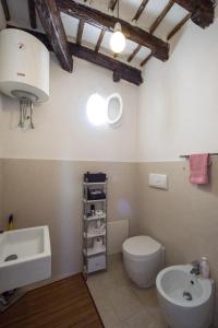 bagno con servizi igienici bianchi e lavandino di Le Luci al Porto a Trapani