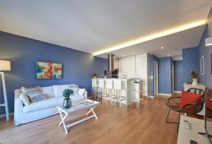 a living room with a white couch and a kitchen at Solar do Monte in Estoril