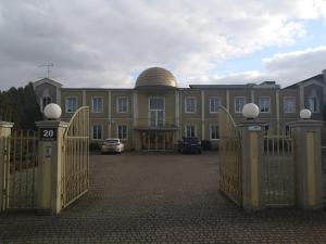 um grande edifício com um portão e um edifício com uma cúpula em Dworek Sobieskiego em Skierniewice