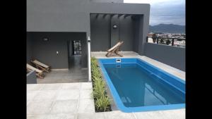 a large blue swimming pool on the side of a house at Monoambiente in Salta