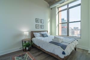 Una cama o camas en una habitación de Convenient 2BR Suite in Prime Location with Gym Access & Optional Parking Near McCormick Place and Soldier Field