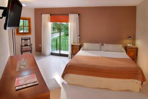 a bedroom with a bed and a table and a television at La Cautiva in Los Reartes