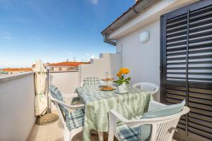 a small balcony with a table and chairs at Apartments Ada near the Sea in Poreč