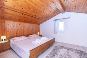 a bedroom with a bed and a wooden ceiling at Apartments Ada near the Sea in Poreč