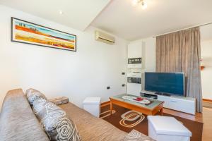a living room with a couch and a flat screen tv at Apartments Ada near the Sea in Poreč