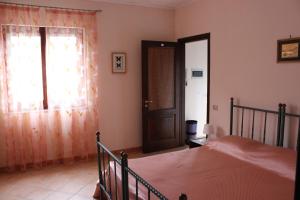 1 dormitorio con cama, ventana y puerta en B&B Villa Ursa Major, en Vico Equense