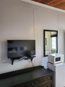 een woonkamer met een flatscreen-tv aan de muur bij Bio Vista Motel in Wainwright