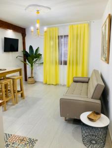 un soggiorno con tende gialle e divano di Chic & Sailor Beach Home a Peñíscola