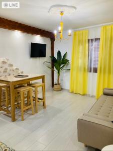 uma sala de estar com uma mesa e cortinas amarelas em Chic & Sailor Beach Home em Peníscola