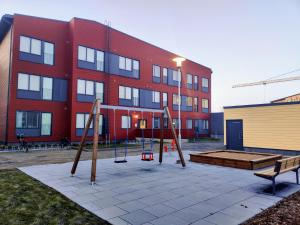 une aire de jeux en face d'un bâtiment rouge dans l'établissement Apartment near the Harbour, à Turku
