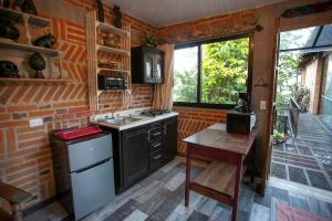 uma cozinha com um fogão, um lavatório e uma mesa em Majikal B&B - Barro Negro em Cholula