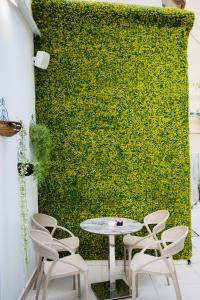 een tafel en stoelen voor een groene muur bij Golden City Hotel & Spa, Tirana in Tirana