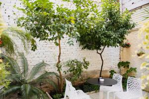 a patio with a table and chairs and trees at Golden City Hotel & Spa, Tirana in Tirana