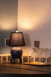 a lamp sitting on a table next to two vases at Hotel Tepeyac in San Cristóbal de Las Casas +81 photos