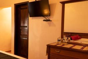 a room with a dresser with a television on the wall at Hotel Tepeyac in San Cristóbal de Las Casas