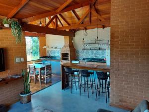 Una cocina con una barra con taburetes. en Villa da Serra Ibitipoca chalé família - 700m do centrinho, en Conceição da Ibitipoca