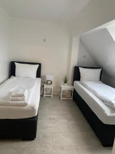 - 2 lits installés l'un à côté de l'autre dans une chambre dans l'établissement City Apartments, à Neumünster
