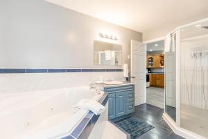 a bathroom with a tub and a sink and a shower at Beach1 Riverfront Resort in Wasaga Beach +77 photos