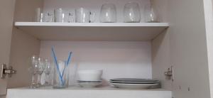 a shelf filled with glass vases and bowls and plates at Departamento en Barrio Centrico Bariloche (PE) in San Carlos de Bariloche +13 photos